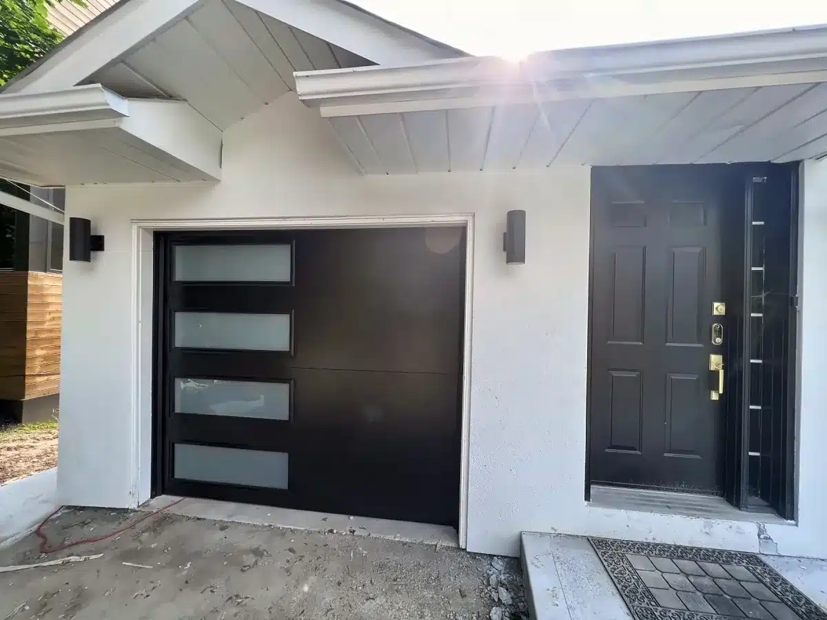 Black modern flush garage door with vertical side windows installed by ADR