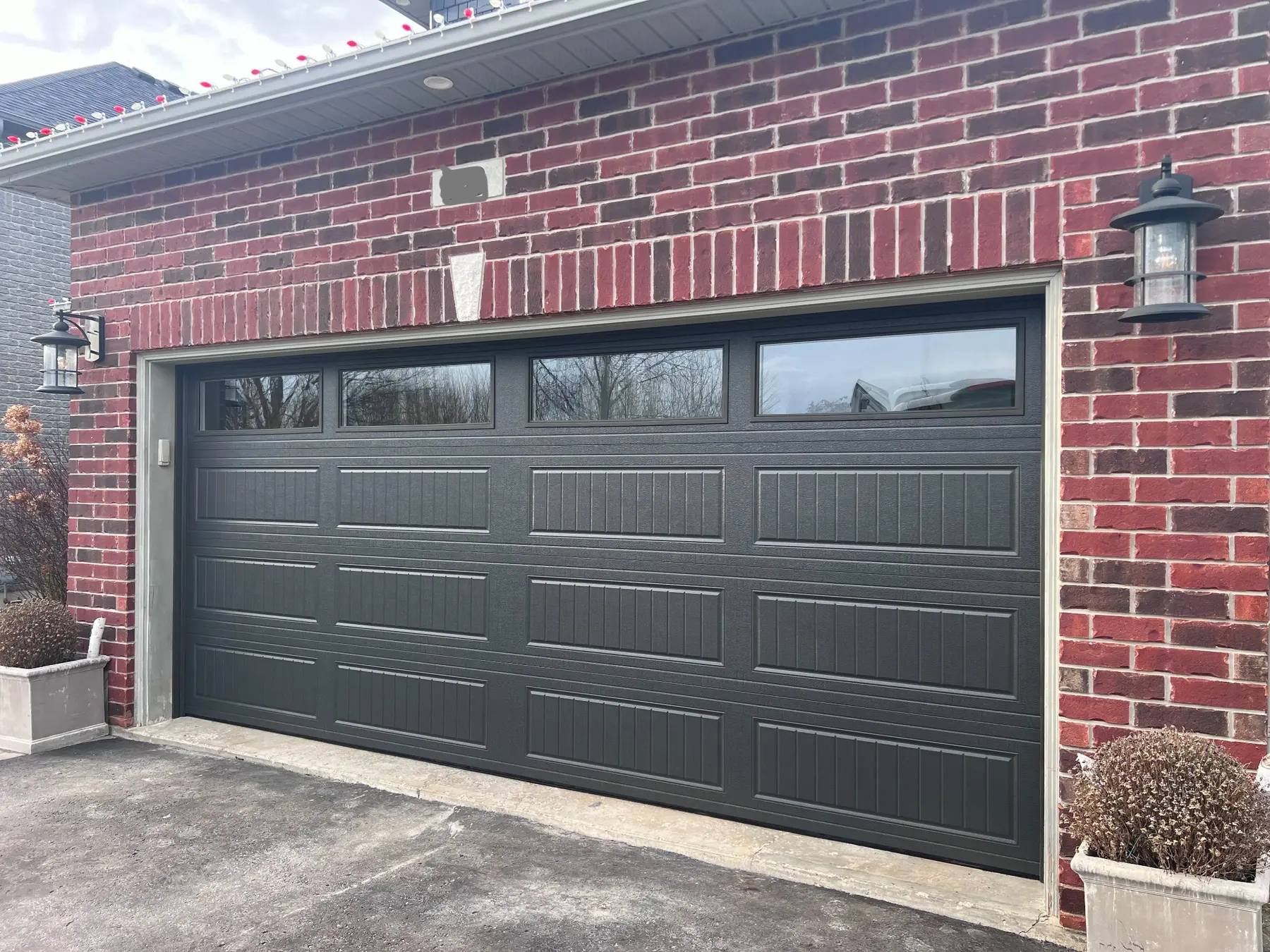 Black carriage-style garage doors with windows after installation