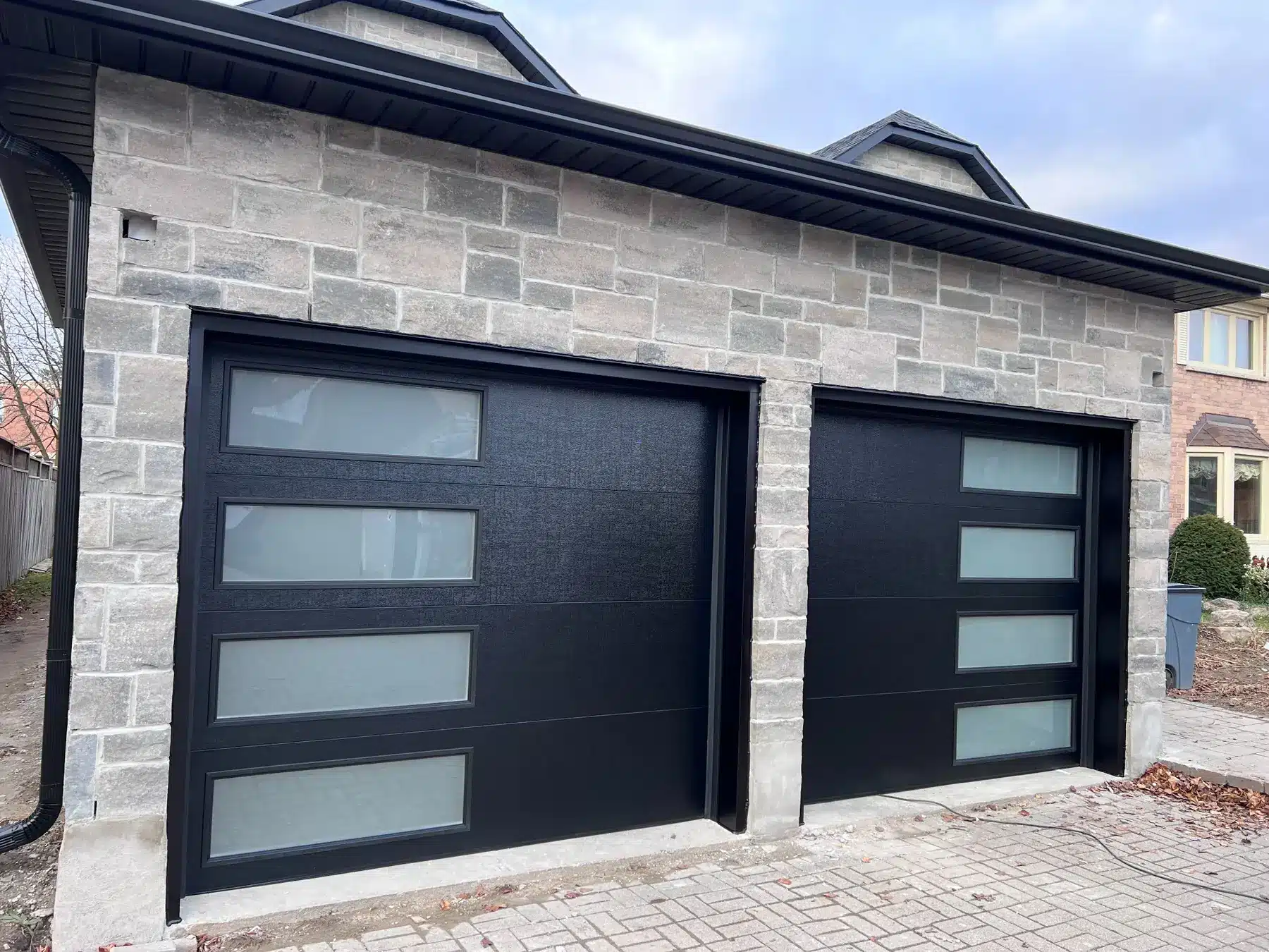 Modern black garage doors with glass panels after installation