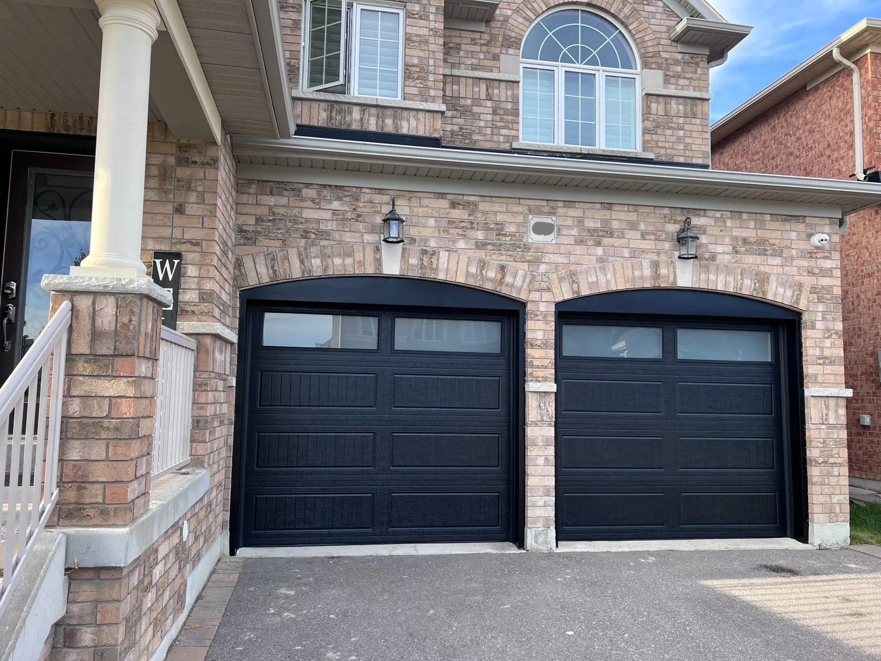 Two black residential garage doors after installation