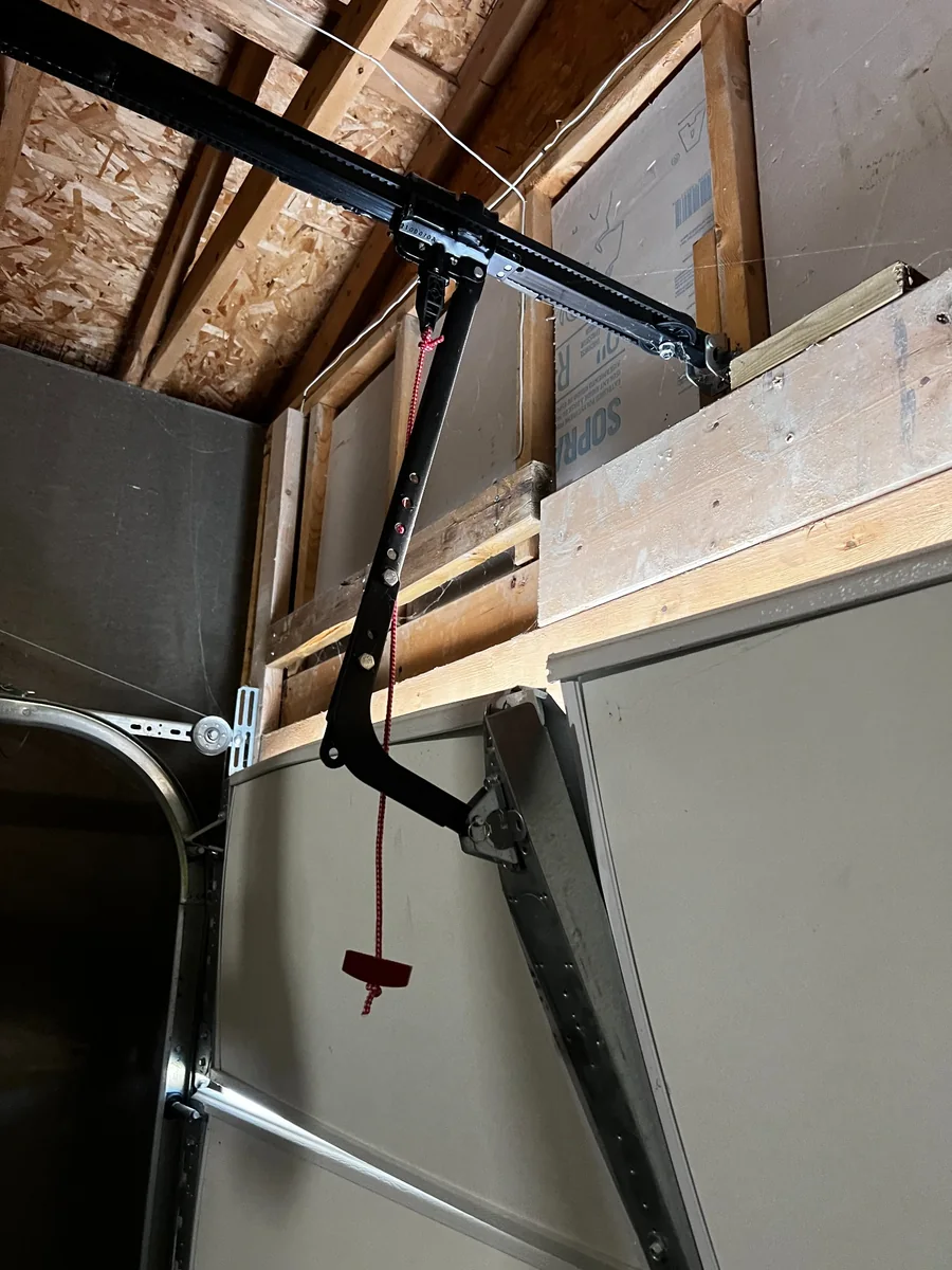 Damaged garage door top panel at the opener arm connection.