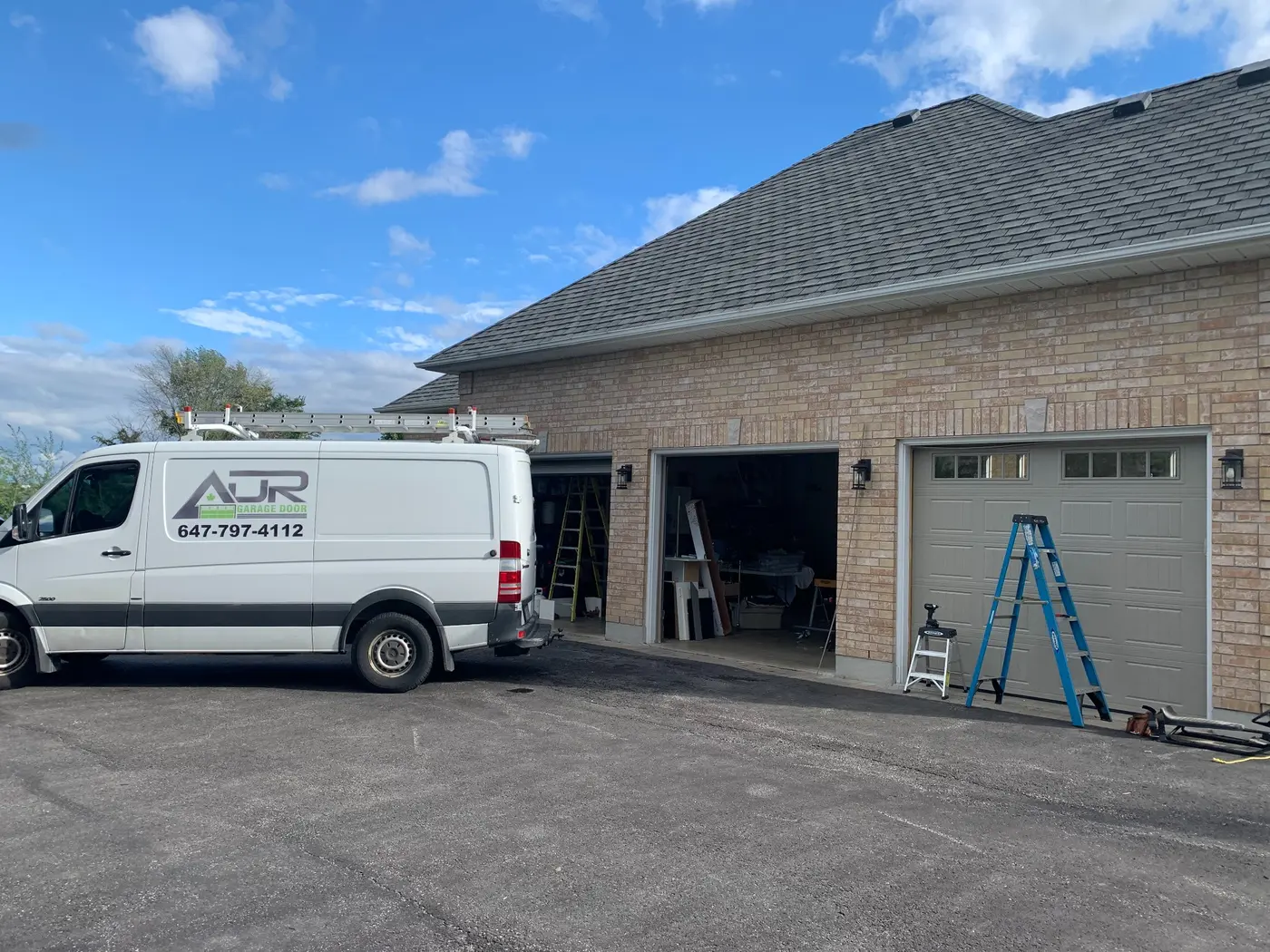 ADR Garage Door service van ADR Garage Door service van outside a brick home with three garage doors