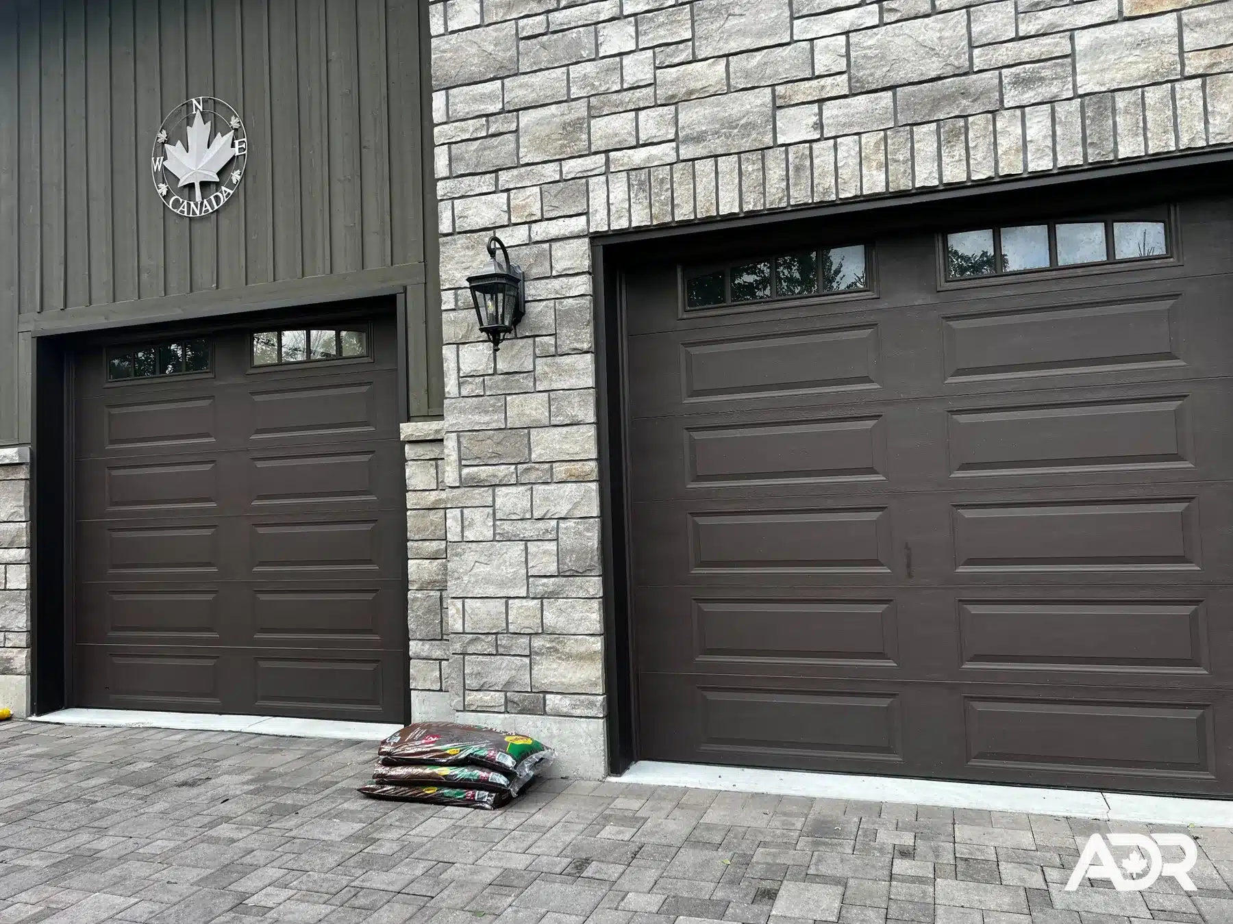 Brown residential garage doors with top windows after installation