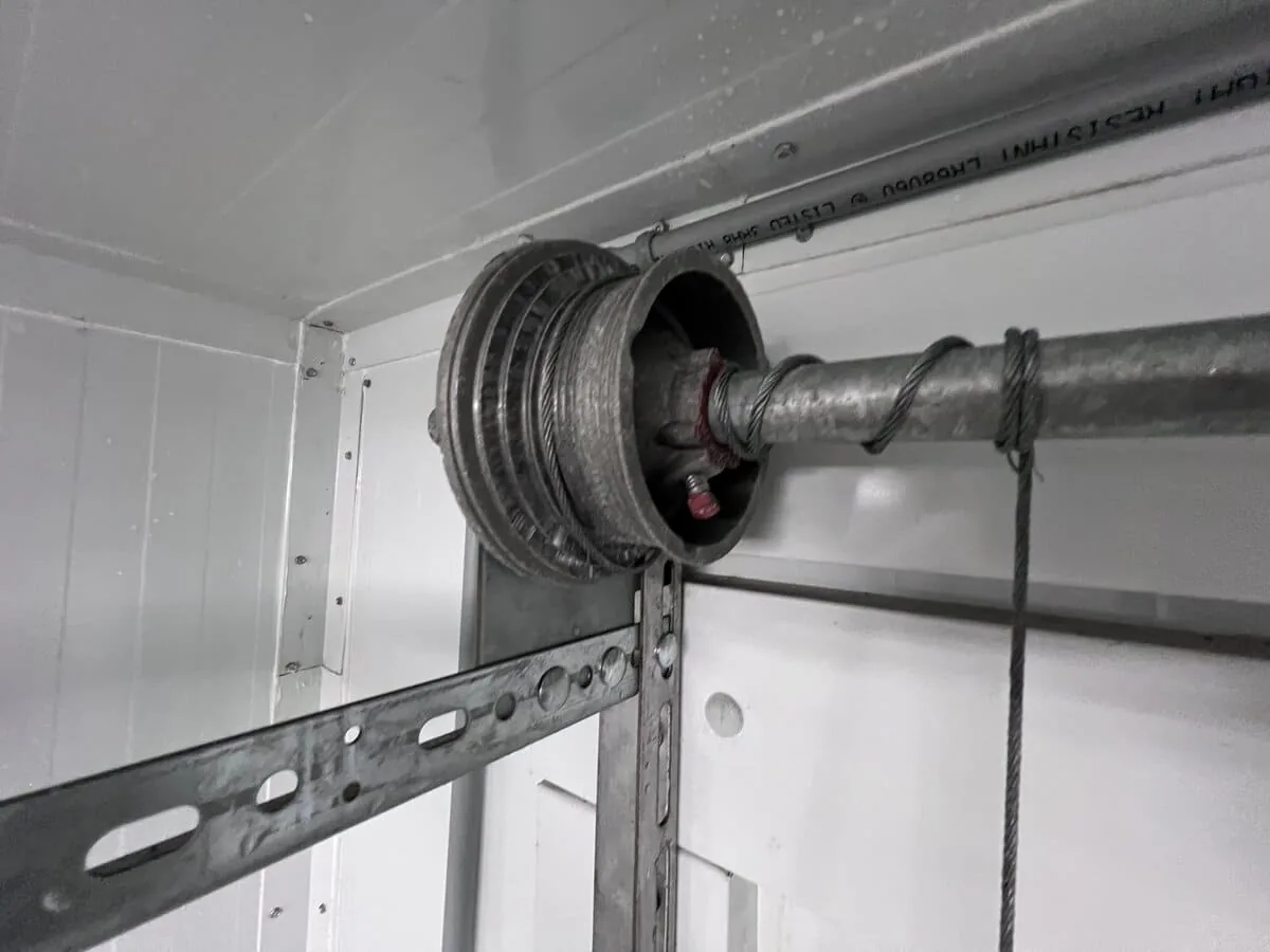 Garage door lifting cable wrapped around the cable drum above the door