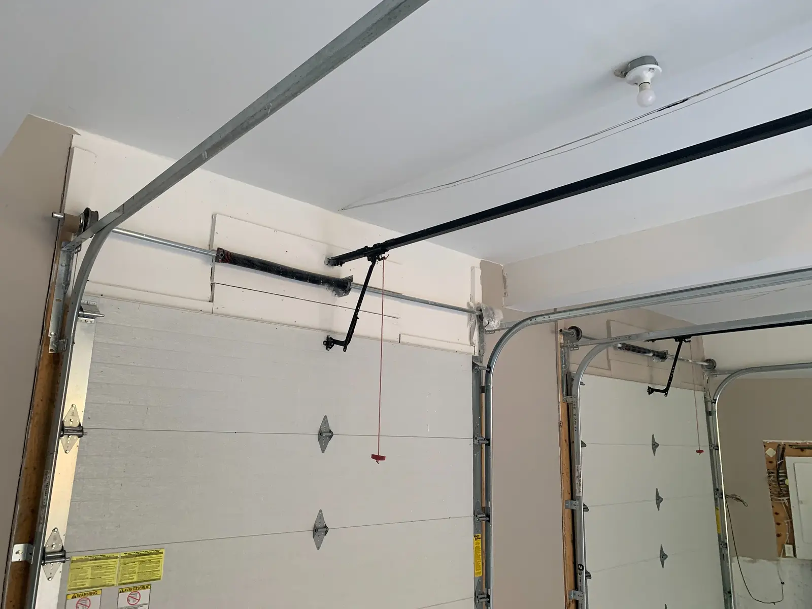 Residential torsion spring assemblies Torsion spring systems above two residential garage doors